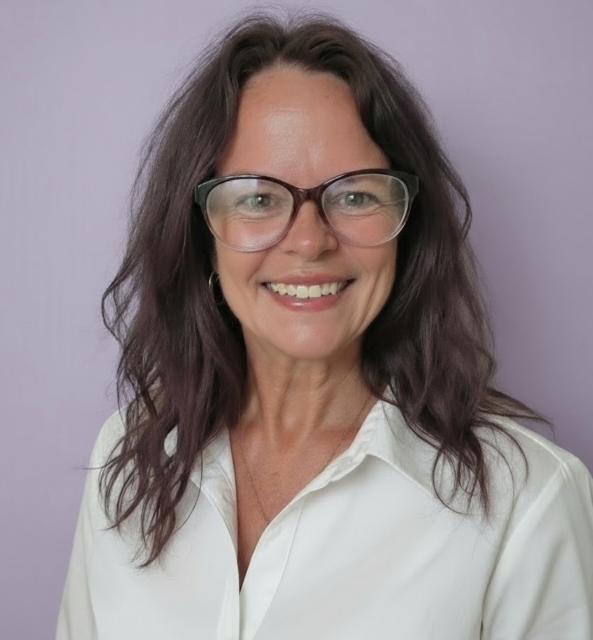 Portrait of Kristy Page, FNP-C, PMHNP-BC — smiling warmly, wearing glasses and a white blouse against a soft lavender background.